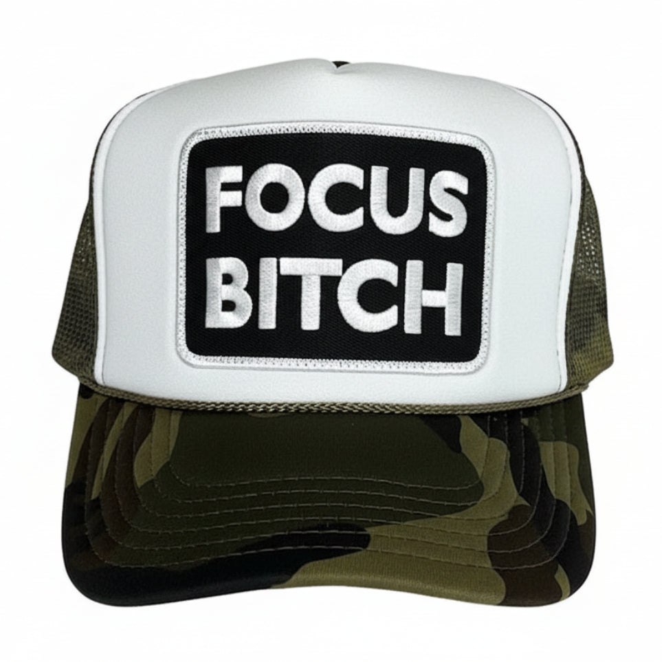 A camouflage trucker hat with 'FOCUS BITCH' embroidered on the front.
